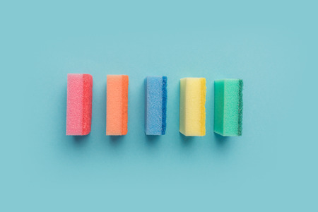top view of row of colorful washing sponges, on blue