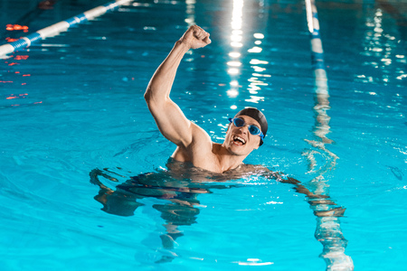 handsome winning muscular swimmer in competition swimming poolの写真素材