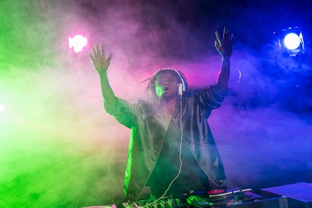professional african american club DJ in headphones in nightclub 
