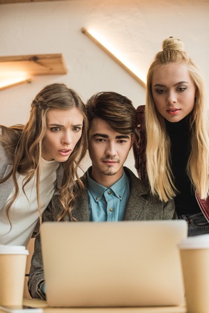 Three People looking at the laptop with surprise