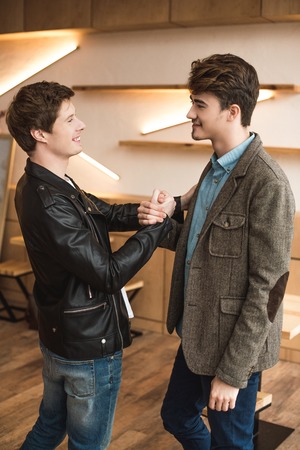 Young men shaking hands in a cafe