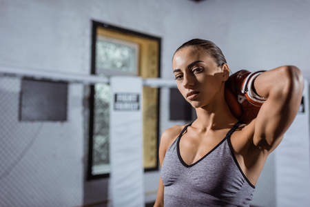 attractive young female boxer in boxing glove looking at cameraの写真素材