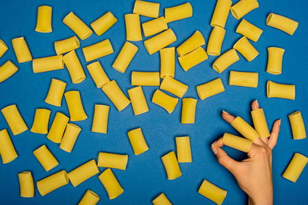 composition of raw spaghetti and woman showing okay sign