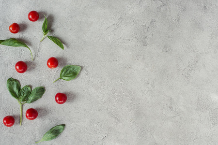 flat lay with arranged cherry tomatoes and spinach on grey tabletopの写真素材
