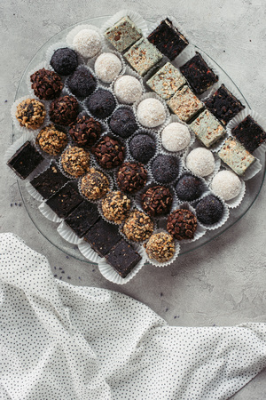 top view of arranged various sweet desserts on plate and tablecloth on grey surfaceの写真素材