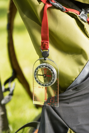 close-up view of compass hanging on backpackの写真素材