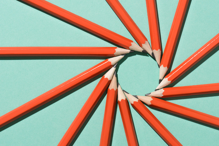 top view of arranged graphite pencils making circle on green