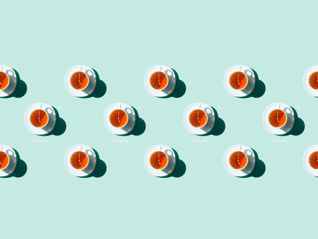 top view of tea time pattern with white tea cups and saucers on blue