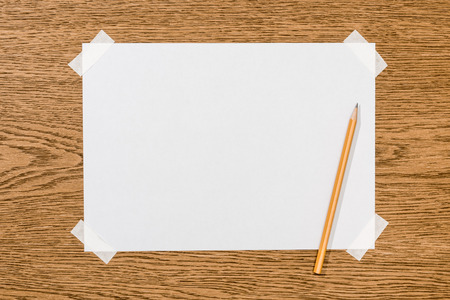 top view of blank white paper and graphite pencil on wooden tableの写真素材