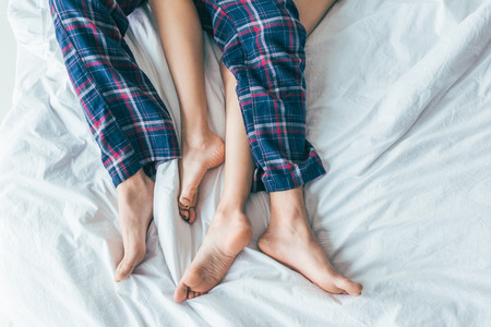 cropped shot of young couple lying together in bedの写真素材