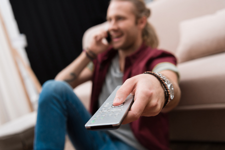 selective focus of man with remote control watching tvの写真素材