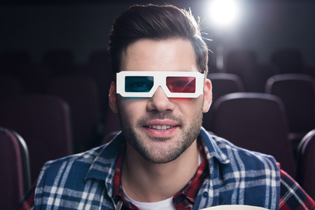 handsome man in 3d glasses watching film in cinema