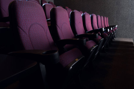 rows of red seats in empty dark cinema