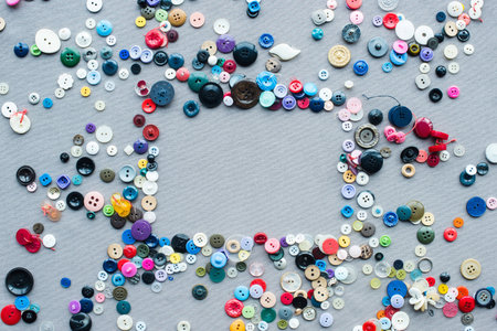 top view of colorful buttons frame on grey cloth backgroundの写真素材
