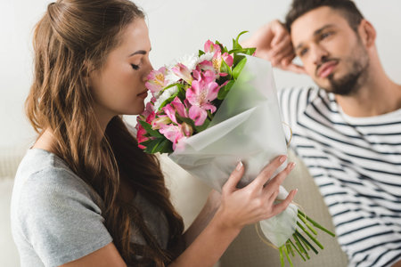 young woman with beautiful bouquet presented by boyfriendの写真素材