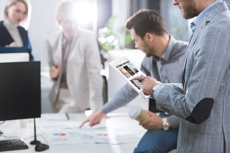 selective focus of businessman using tablet during work in officeのeditorial素材