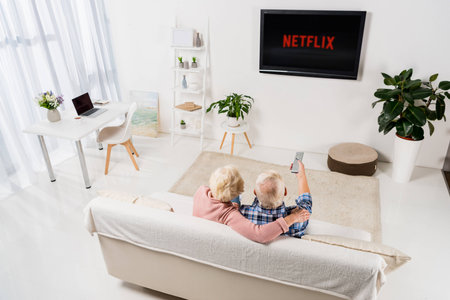 senior couple watching netflix on tv at homeのeditorial素材