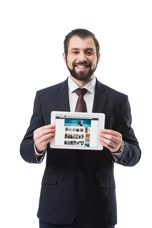 smiling businessman showing digital tablet with amazon website, isolated on whiteのeditorial素材
