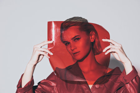 attractive style girl posing with red filter for fashion shoot, isolated on grey