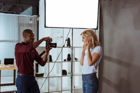 african american photographer taking photo of attractive model in studioの写真素材