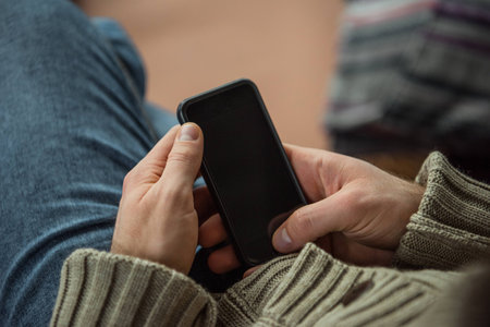 Cropped image of man holding smartphone in handsの写真素材