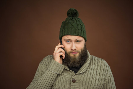 Man in green hat talking by smartphone