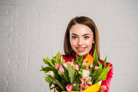 Portrait of beautiful woman with bouquet of colored flowersの写真素材