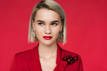 attractive girl in red suit with boutonniere, isolated on redの写真素材