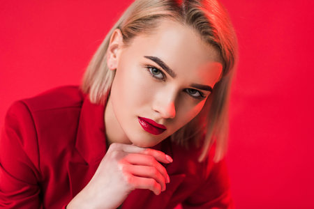 portrait of blonde elegant fashionable girl, isolated on redの写真素材