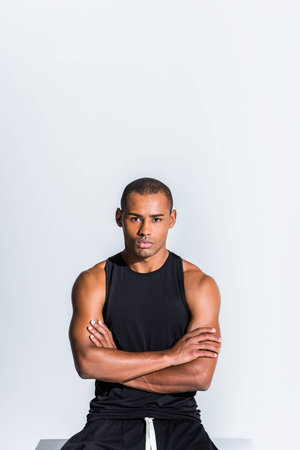 confident young african american sportsman with crossed arms looking at camera isolated on greyの写真素材