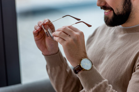 cropped image of smiling man holding glassesの写真素材