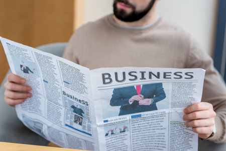 Cropped image of man reading business newspaperの写真素材