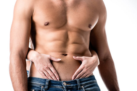 midsection image of man torso with female hands isolated on whiteの写真素材