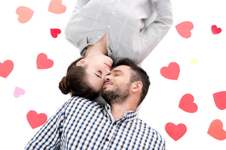 overhead view of couple lying with paper hearts isolated on white, valentines day conceptの写真素材