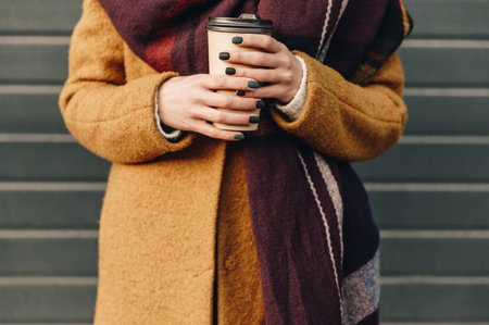 cropped shot of of woman in autumn jacket holding coffee to go in handsの写真素材