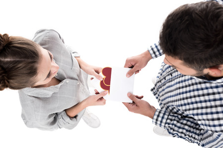 overhead view of boyfriend giving valentines postcard to girlfriend isolated on whiteの写真素材