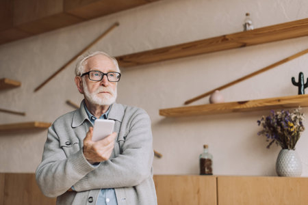 thoughtful senior man with smartphone looking away