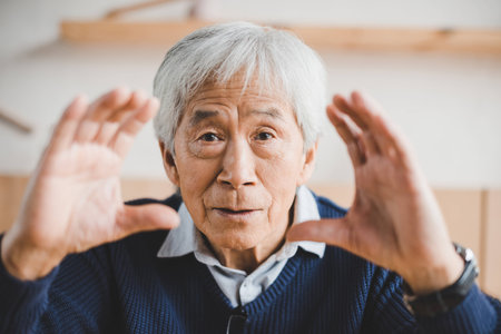 senior asian man making frame with hands while looking at camera