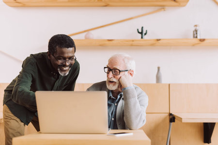 multiethnic senior men using laptop togetherの写真素材