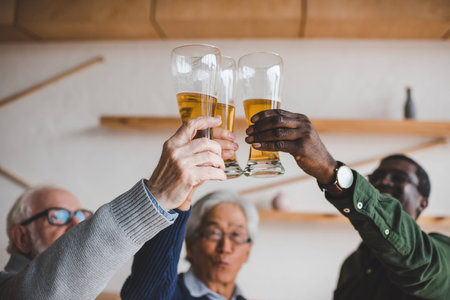 group of senior friends clinking glasses of beer at barの写真素材
