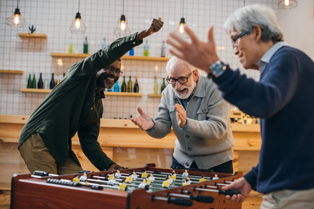 group of senior friends playing foosball at bar