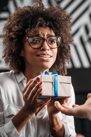 beautiful happy african american woman carefully holding gift