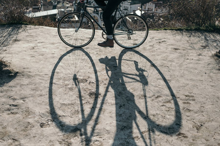 cropped shot of man riding bicycle on rural road