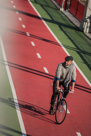 high angle view of handsome adult man riding bicycle on freshly painted biking roadの写真素材