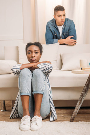 front view of frustraited african american couple beside couch at homeの写真素材