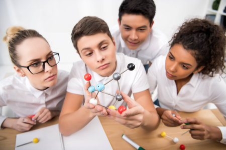 young students picking molecular model for chemistry lesson