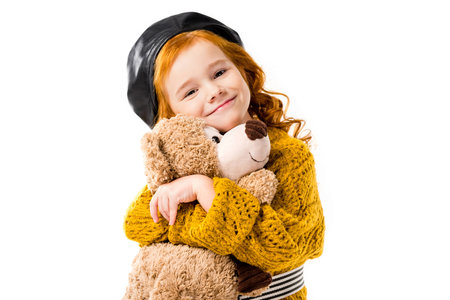 happy red hair child hugging teddy bear isolated on whiteの写真素材
