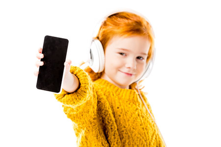 red hair kid showing smartphone isolated on whiteの写真素材