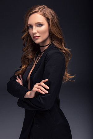 woman with crossed hands looking at camera isolated on grayの写真素材