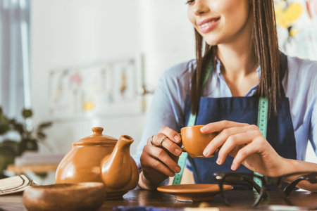 cropped image of seamstress drinking tea during lunchの写真素材
